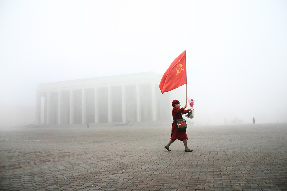Woman carries USSR flag on Kastrychnickaja square  rally which marks the 1917 Bolshevik Revolution anniversary. This day is a state holiday in Belarus.